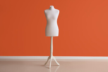 Mannequin for tailor near orange wall