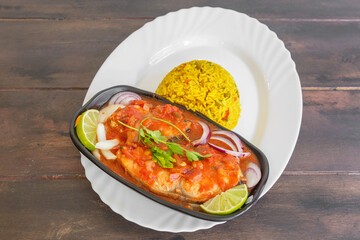 Court-bouillon de poisson servi avec riz Madras, plat créole typique des Antilles sur une table en bois. 