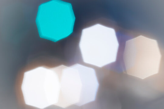 Photo White and turquoise octagonal bokeh on black background – abstract geometric holiday background, front view bokeh like in the movies