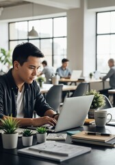 Focused young man typing on laptop in modern office workspace with greenery and colleagues