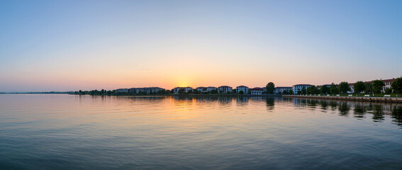 Sunrise over calm waters with reflections in tranquil lakeside setting