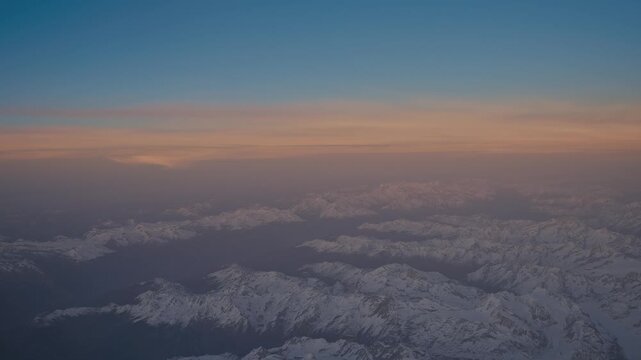 Aerial View of Snowy Mountains at Sunset