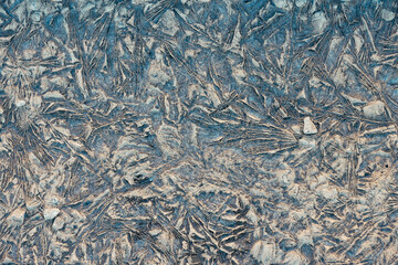 Natural blue and brown abstract patterns on rough surface of frozen mud