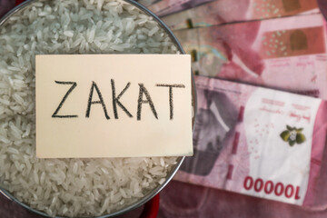 A concept of Zakat al-Fitr and Eid al-Fitr alms, featuring a pot of rice, a sticky note with "Zakat" written on it, and rupiah banknotes.