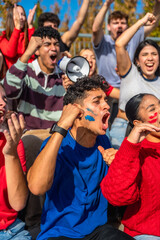 Fototapeta premium Enthusiastic sports fans cheering with face paint in stadium