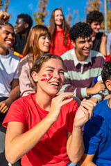 Diverse friends enjoying sports event clapping and cheering