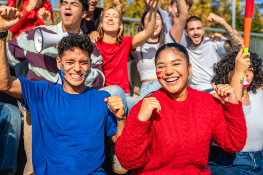 Diverse sports fans cheering for team in stadium