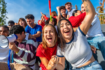 Young friends cheering at sports event celebrating victory