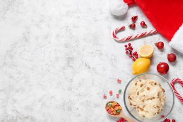 Bowl of dough for Panettone with ingredients and Christmas decor on white grunge background