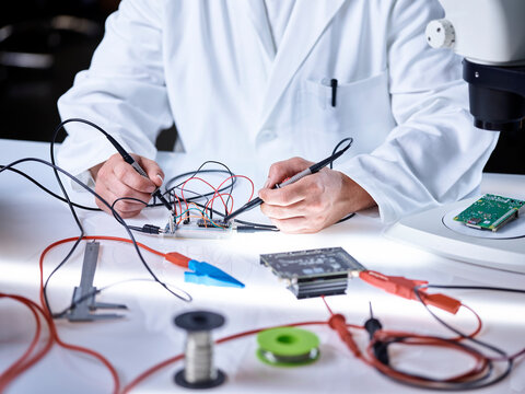 Hands of scientist working on circuit board in laboratory