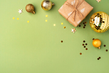 Christmas gift with gold ornaments on a green background.
