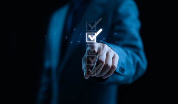 Businessman selecting glowing digital checkbox on virtual screen, symbolizing success, completion, task management, and digital business productivity concept.