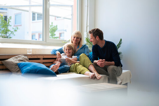 Happy parents with son using tablet PC at home