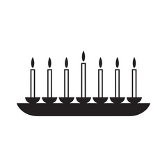 Silhouette of a candelabra with seven lit candles on a dark background