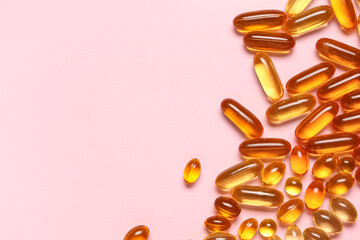 Vitamin E capsules on pink background