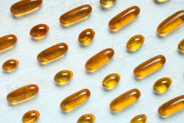 Vitamin E capsules on light blue background
