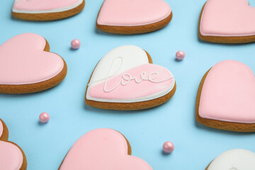 Sweet heart-shaped cookies and sprinkles on blue background, closeup. Valentine's Day celebration