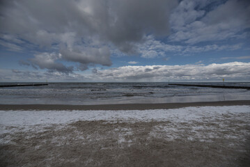 WINTER TIME - Snow on the sea beach and cumulus clouds over the sea