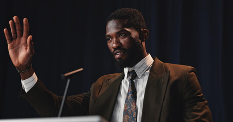 Black man, speaker and wave with mic for speech, country congress or political statement on podium. Event, male person or African politician with seminar for government pitch, democracy or election