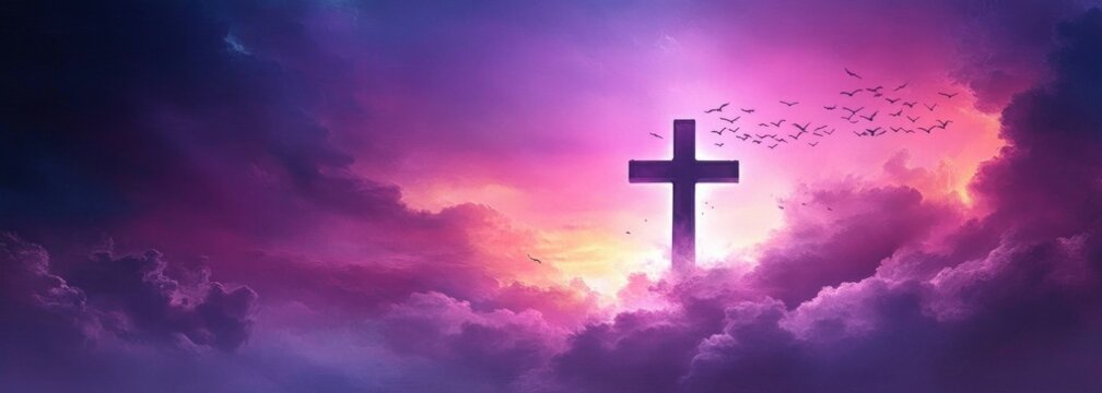 Large cross illuminated by vibrant purple and pink glowing clouds at sunset with birds flying through the dramatic sky