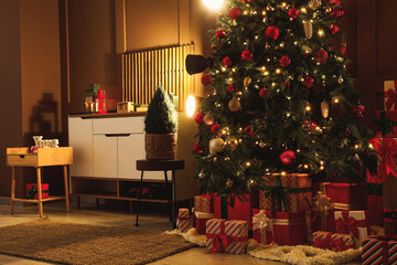 Decorated Christmas tree with many gifts, commode and glowing lamps in living room at night
