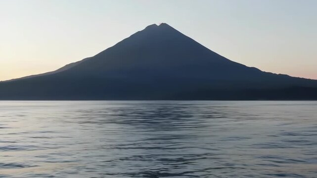 Mountain silhouette at sunset with water reflections, usable for serene backgrounds or art prints