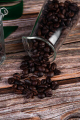 Coffee beans and props in a clear glass with a wooden background.