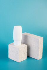 White cosmetic product or sunscreen cosmetic with stylish props on blue background.