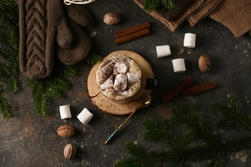 Cup of hot chocolate with marshmallows, warm clothes and decor on dark grunge background