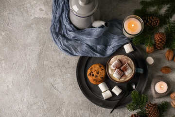 Cup of hot chocolate with marshmallows, cookies and winter decor on grey grunge background