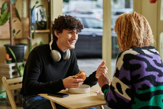 Stylish couple enjoys a cozy moment at a trendy cafe sharing laughter and delicious food