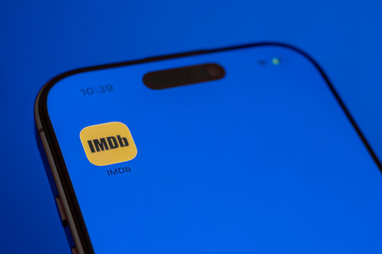 Cairo, Egypt - 11 07 2025: Mobile phone showing "IMDB" icon on a blue background. Social media icons on the digital screen of the phone	