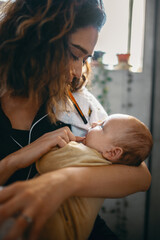Mother brushes teeth while holding her baby