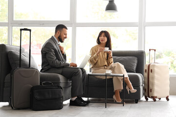 Young business people waiting for their flight in airport lounge