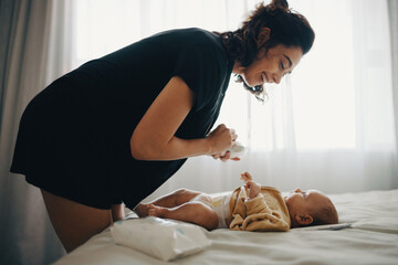 Mother changing baby’s diaper