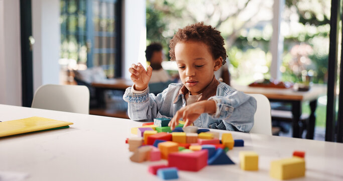 Learning, kid or playing with building blocks in home for fine motor skills, problem solving or creativity. Education, african boy and toys on table for cognitive development and sensory imagination