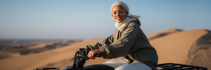 Young asian female smiling on atv in desert landscape