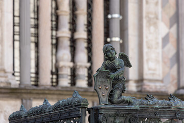 Decorative bronze angel holding the Colleoni family shield near the chapel in Bergamo Lombardy, sculptural fence element reflecting the blend of Renaissance