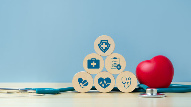 Health insurance concept on wooden block with Red heart and shapedoctor physician's stethoscope on blue background. Family life insurance and policy concepts, hospital, medical treatment. copy space.