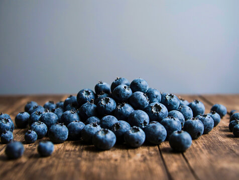 A pile of fresh blueberries on a rustic wooden table - Powered by Adobe