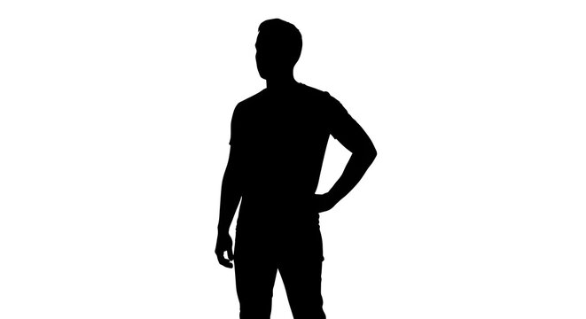 Silhouette of a man standing with his hand on his hip against a white background in a studio shot