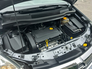 Engine bay exposed with intricate machinery showcasing mechanical precision in a modern car at a...
