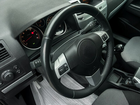 Detail perspective of a modern car interior showcasing the steering wheel and controls in an intricate design that emphasizes functionality and design aesthetics - Powered by Adobe