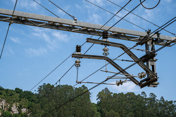 A power line with a blue sky in the background. The sky is clear and the sun is shining