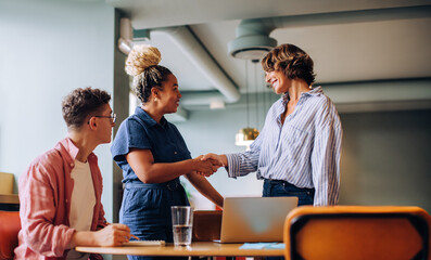 Group of colleagues meeting with a handshake in an office environment
