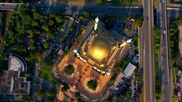 Aerial view of Abuja National Mosque with its golden dome contrasting with surrounding greenery and roadways, Abuja, Federal Capital Territory, Nigeria.