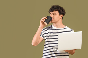 Male programmer with laptop drinking coffee on green background