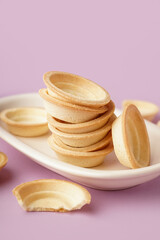 Bowl with homemade tartlets on lilac background