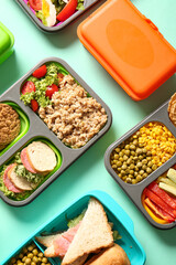 Many lunchboxes with different delicious food on turquoise background