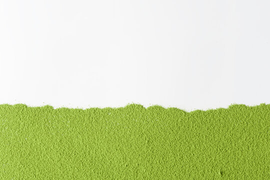 Flat layer of vibrant green matcha powder aligned horizontally over clean white surface creates bold contrast and minimalist mockup